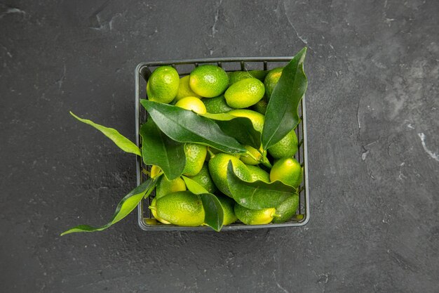 Top close-up view fruits fruits with leaves in the dark basket