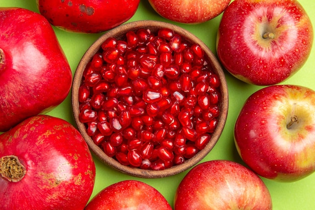 Free photo top close-up view fruits pomegranates apples brown bowl of seeds of pomegranate