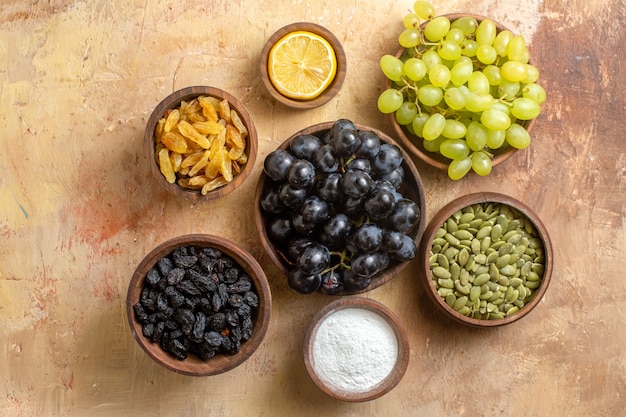 Top close-up view grapes the appetizing bunches of grapes raisins sugar lemon pumpkin seeds