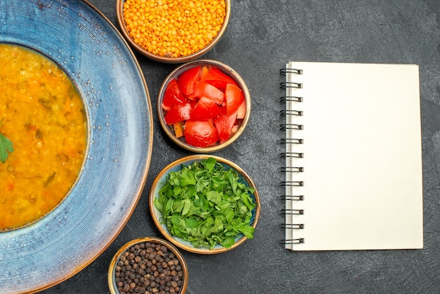 Free photo top close-up view lentil soup lentil soup tomatoes spices white notebook herbs