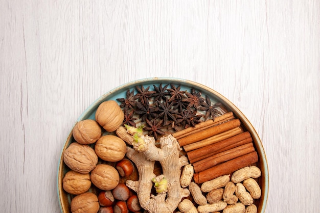 Top close-up view nuts hazelnuts walnuts peanuts cinnamon and star anise on the table