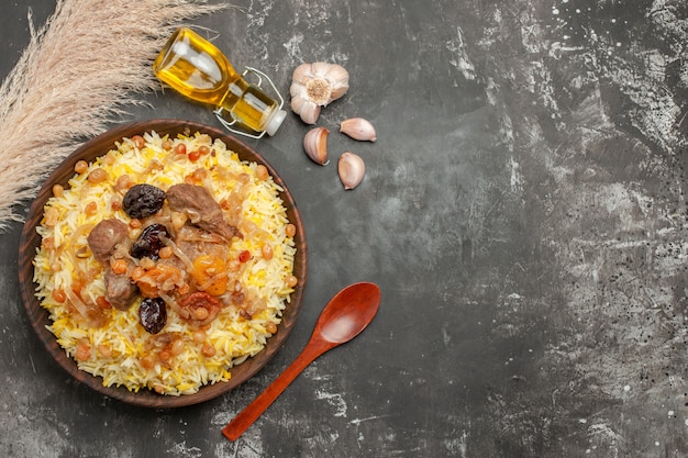 Free Photo top close-up view pilaf garlic bottle of oil wooden spoon an appetizing pilaf