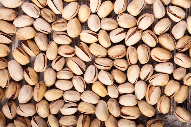 Over top close up view of Pistachios on wooden background in studio photo. Healthy delicious snacks