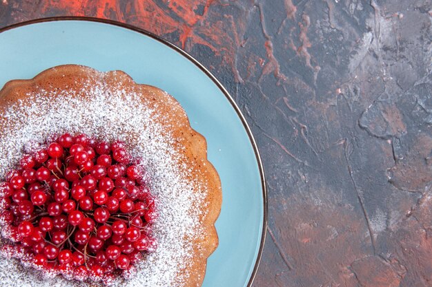 Top close-up view a plate blue plate of an appetizing cake with berries on the table