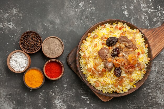 Top close-up view spices an appetizing pilaf on the board colorful spices