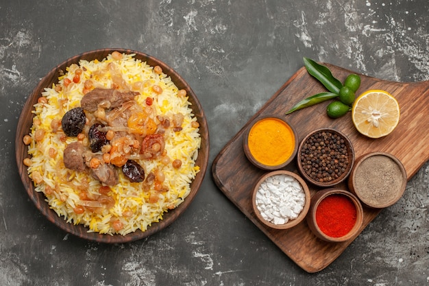 Free photo top close-up view spices an appetizing pilaf on the cutting board colorful spices on the board