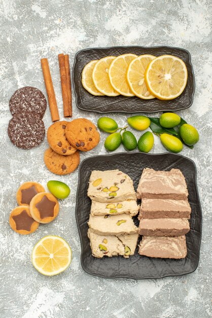 Top close-up view sweets sliced lemon sunflower seed halva cinnamon cookies