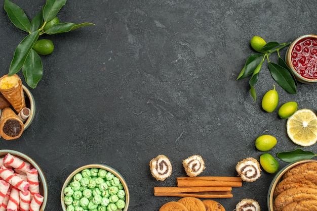 Top close-up view sweets waffles cookies colorful sweets jam cinnamon citrus fruits with leaves