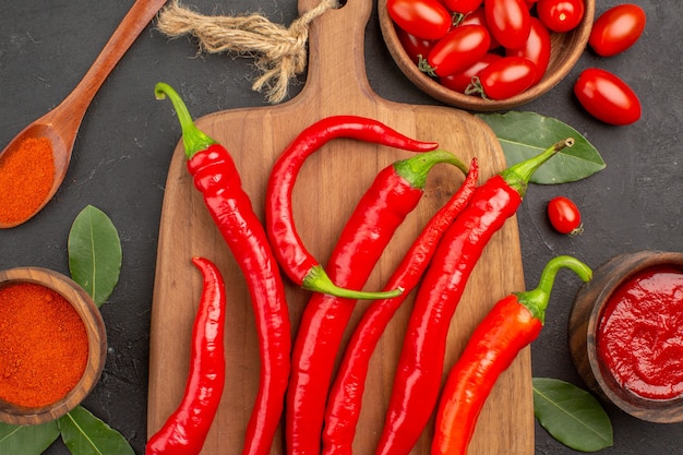 Free photo top close view a bowl of cherry tomatoes hot red peppers on the chopping board