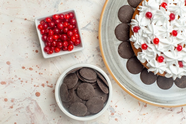 Top close view cake with pastry cream berries and chocolate in bowls