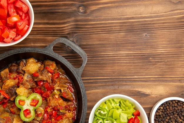 Free photo top close view cooked vegetable meal with sliced bell-pepper salad on brown desk