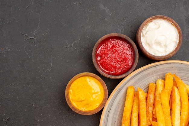 Free Photo top close view delicious french fries with seasonings on dark space