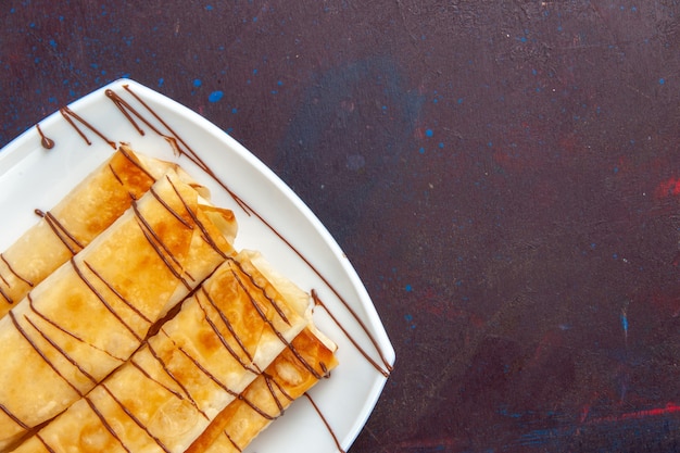 Free photo top close view delicious sweet pastries inside plate on dark space