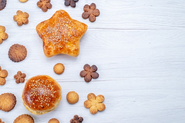 Free photo top close view of delicious sweet pastries with cookies on light desk, pastry cookie biscuit sweet sugar