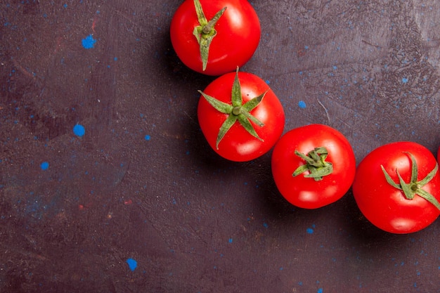 Top close view fresh red tomatoes circled on the dark space