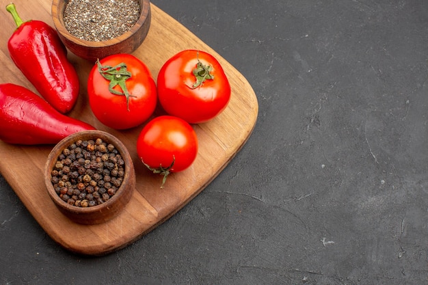 Top close view fresh red tomatoes with seasonings on dark space