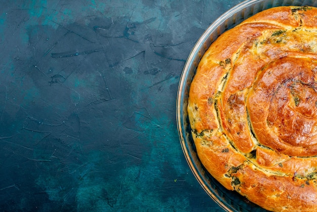 Top close view greeny pastry with greens inside on dark background.