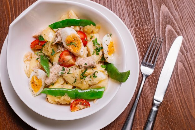 Top close view of italian potato salad bowl with tuna beans and cherry tomato