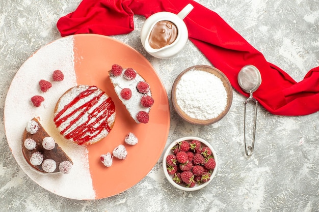 Top close view of plate of sweet dessert with chocolate tea sieve berries and red napkin on side on marble background