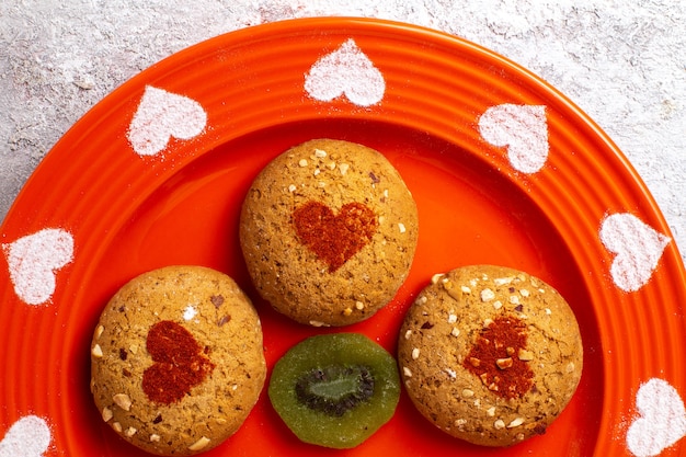 Top close view round sugar cookies inside plate on a white surface cookie biscuit sugar sweet cake