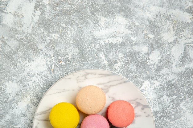 Top closer view yummy french macarons colorful cakes on white surface cake sugar biscuit sweet pie cookie