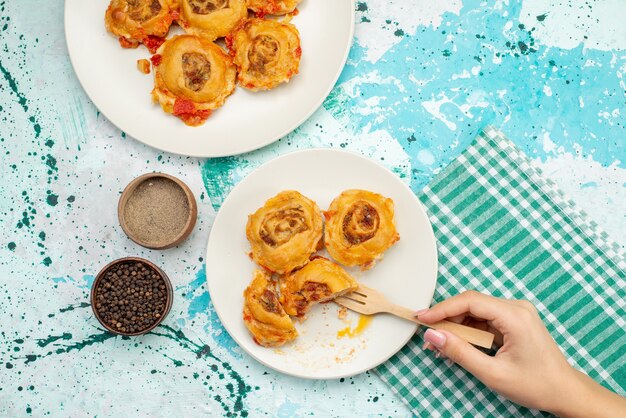 Top distant view cooked dough meal with minced meat inside plates on bright-blue desk, dough food meat calorie color