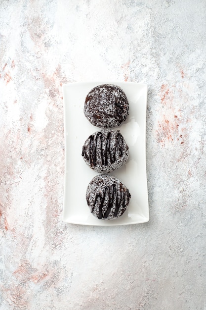 Top distant view delicious chocolate cakes with icings on white surface chocolate sugar biscuit sweet cake bake cookie