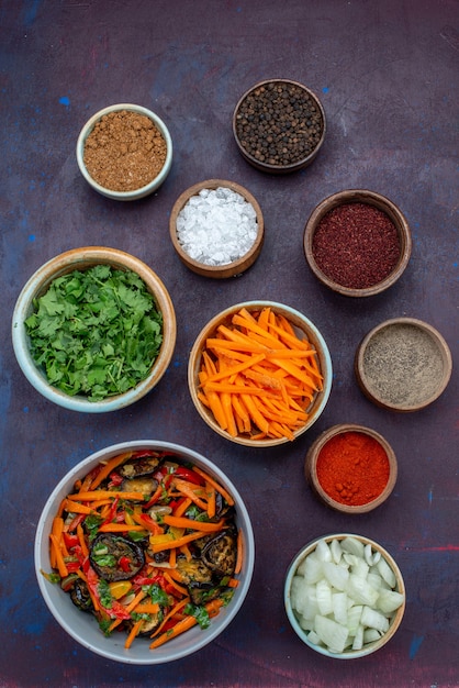 Free Photo top distant view greens and seasonings with sliced onions and vegetable salad on dark desk salad food meal vegetable snack