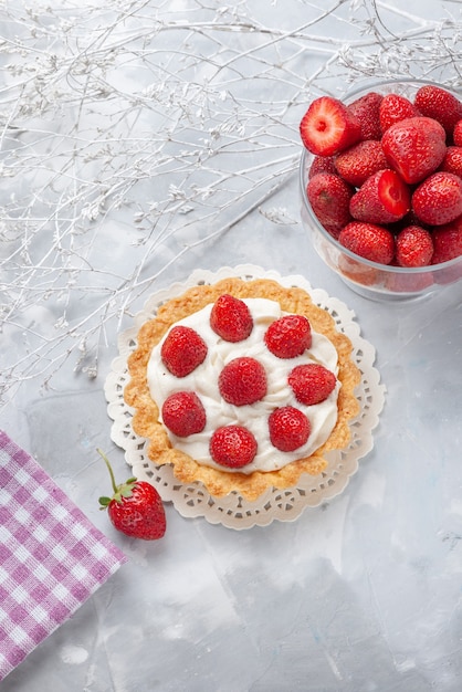 Free photo top distant view of little cake with cream and fresh red strawberries on white, cake fruit berry biscuit cream bake