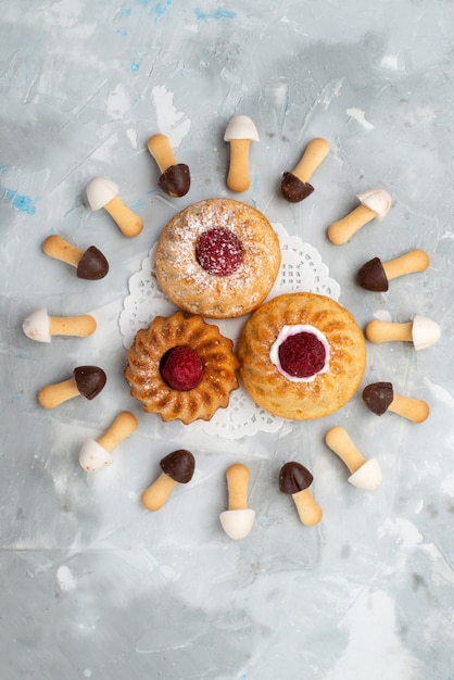 Free photo top distant view little delicious cakes with chocolate biscuits on the grey surface