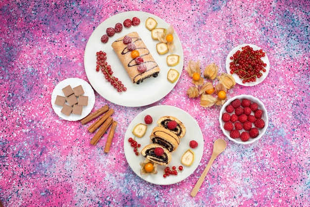 Free photo top distant view roll cake with fruits inside white plate on the colored background cake biscuit sweet color