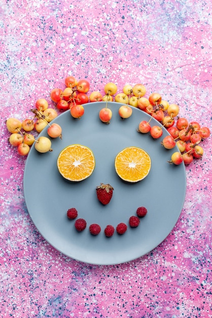 Free photo top distant view smile from fruits inside plate on bright pink desk fruit fresh ripe mellow color