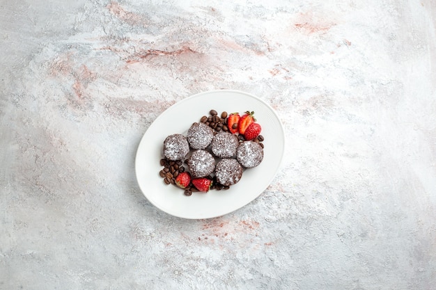 Top distant view tasty chocolate cakes with strawberries and chocolate chips on white surface biscuit cake bake sugar sweet pie cookie