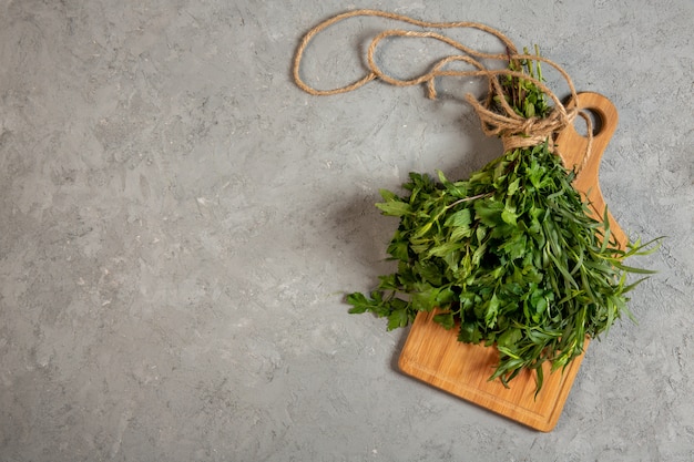 top  fresh herbs on wooden cutting board on grey