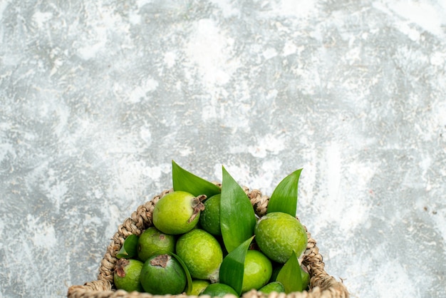 Free Photo top half view fresh feijoas in wicker basket on grey isolated surface free space