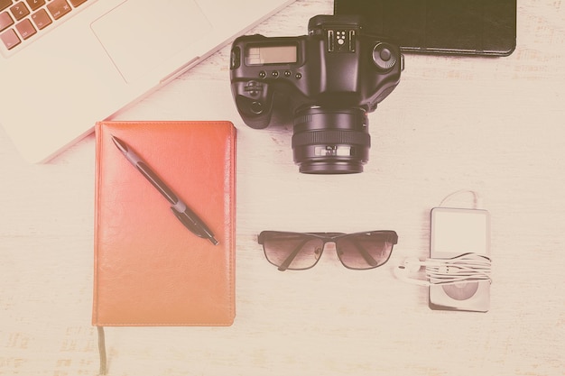 Over top photo of camera and laptop in vintage tone on wooden background