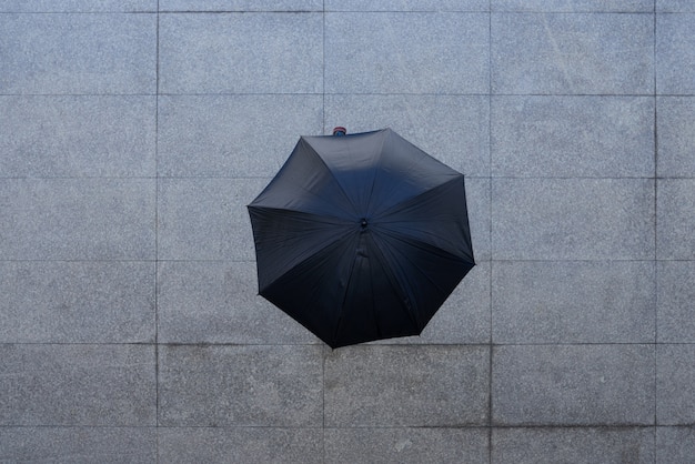 Free photo top shot of unrecognizable person standing under umbrella on pavement