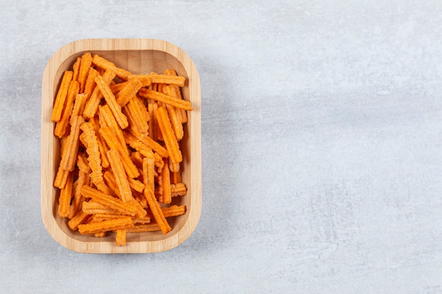 Top up view of chips on wooden plate.