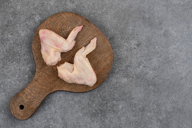 Free Photo top up view of two fresh raw chicken wing on wooden cutting board