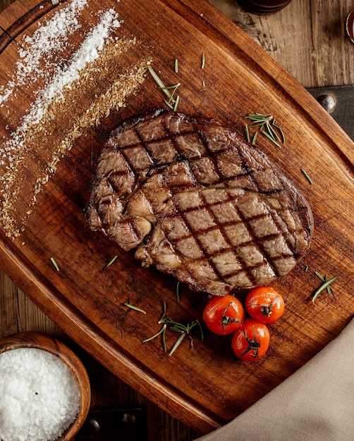 Free Photo top veiw of grilled beef steak served on wooden board