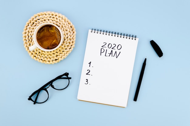 Top view 2020 resolutions plan with coffee and glasses