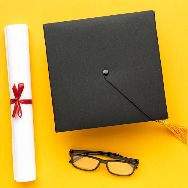 Top view of academic cap with diploma and glasses