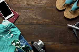 Free photo top view accessories  travel with mobile phone,camera,sunglasses,cloth woman,sandal on table wooden with copy space.travel concept.