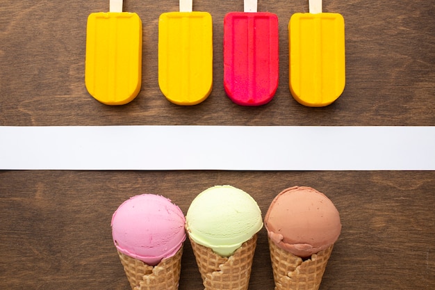 Free photo top view aligned ice cream on sticks and cones