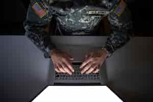 Free photo top view of american soldier in military uniform typing on the computer