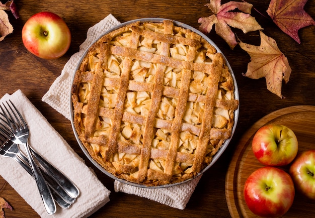 Free photo top view of apple pie for thanksgiving with cutlery and leaves