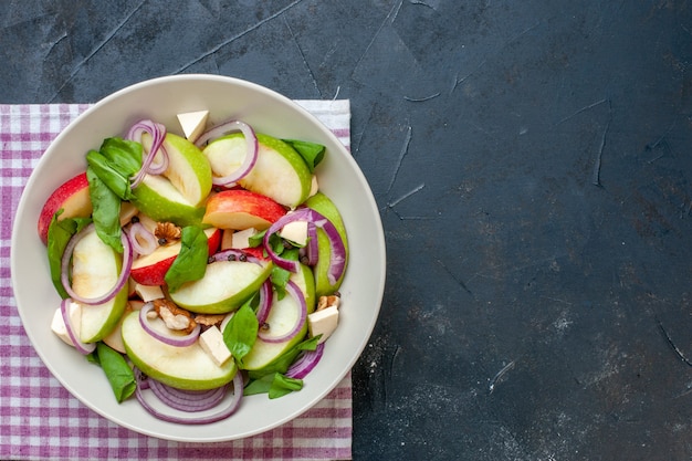 Free Photo top view apple salad in bowl purple and white checkered napkin on dark table with copy place