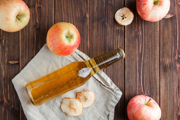 Top view apples with apple juice on cloth and wooden background. horizontal