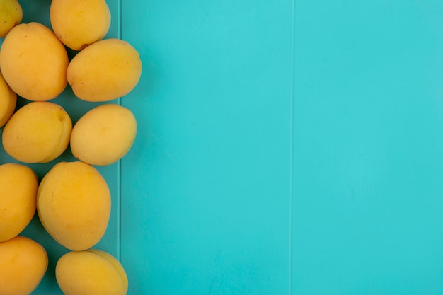 Top view of apricots on a blue surface