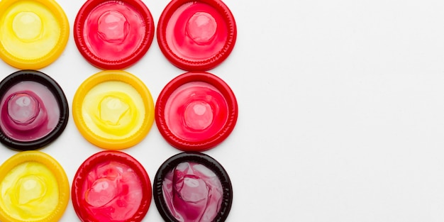 Top view arrangement of colorful condoms with copy space